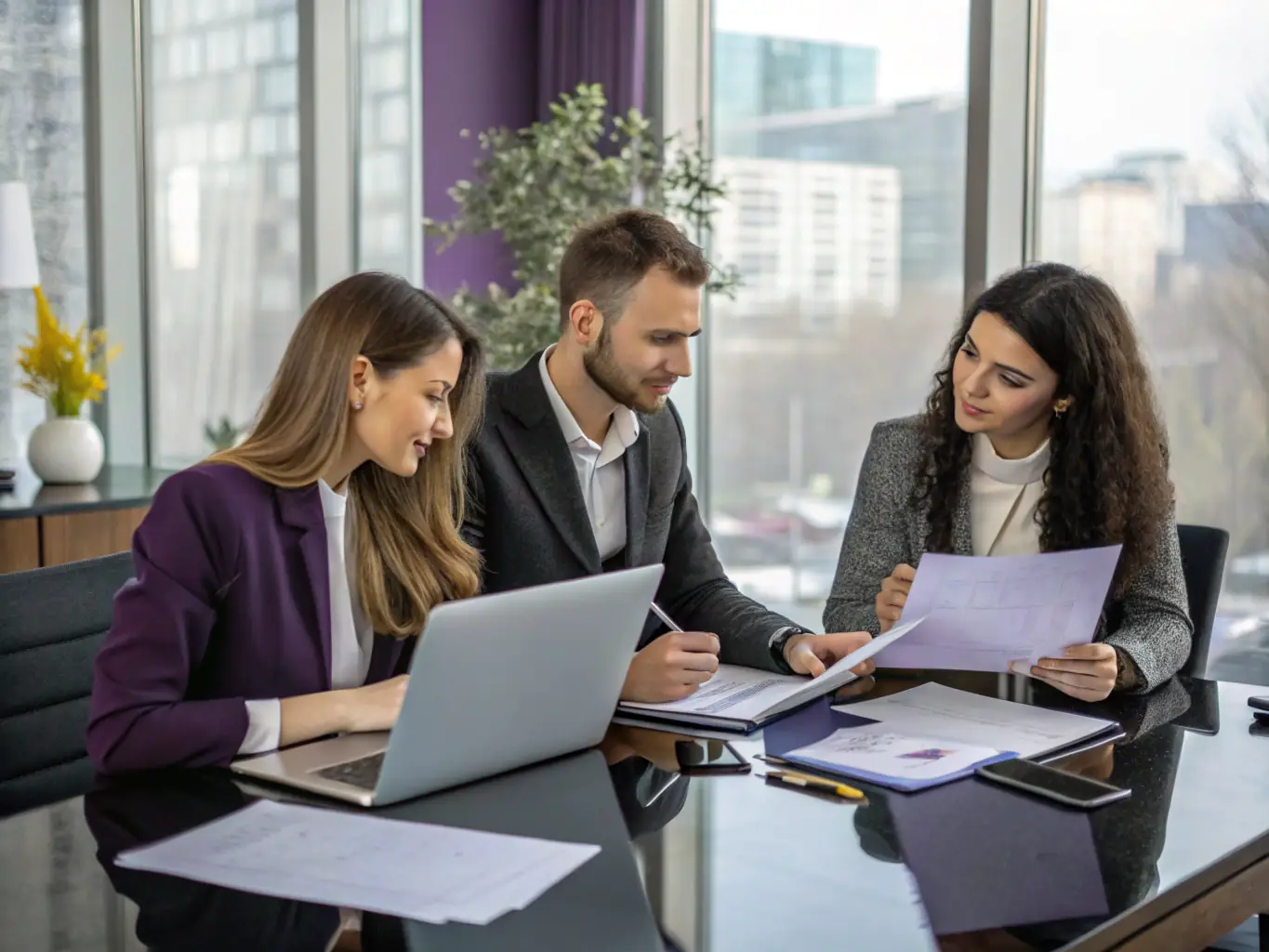 A team of consultants collaborating on a project, using laptops and discussing strategies, symbolizing the implementation and development phase.